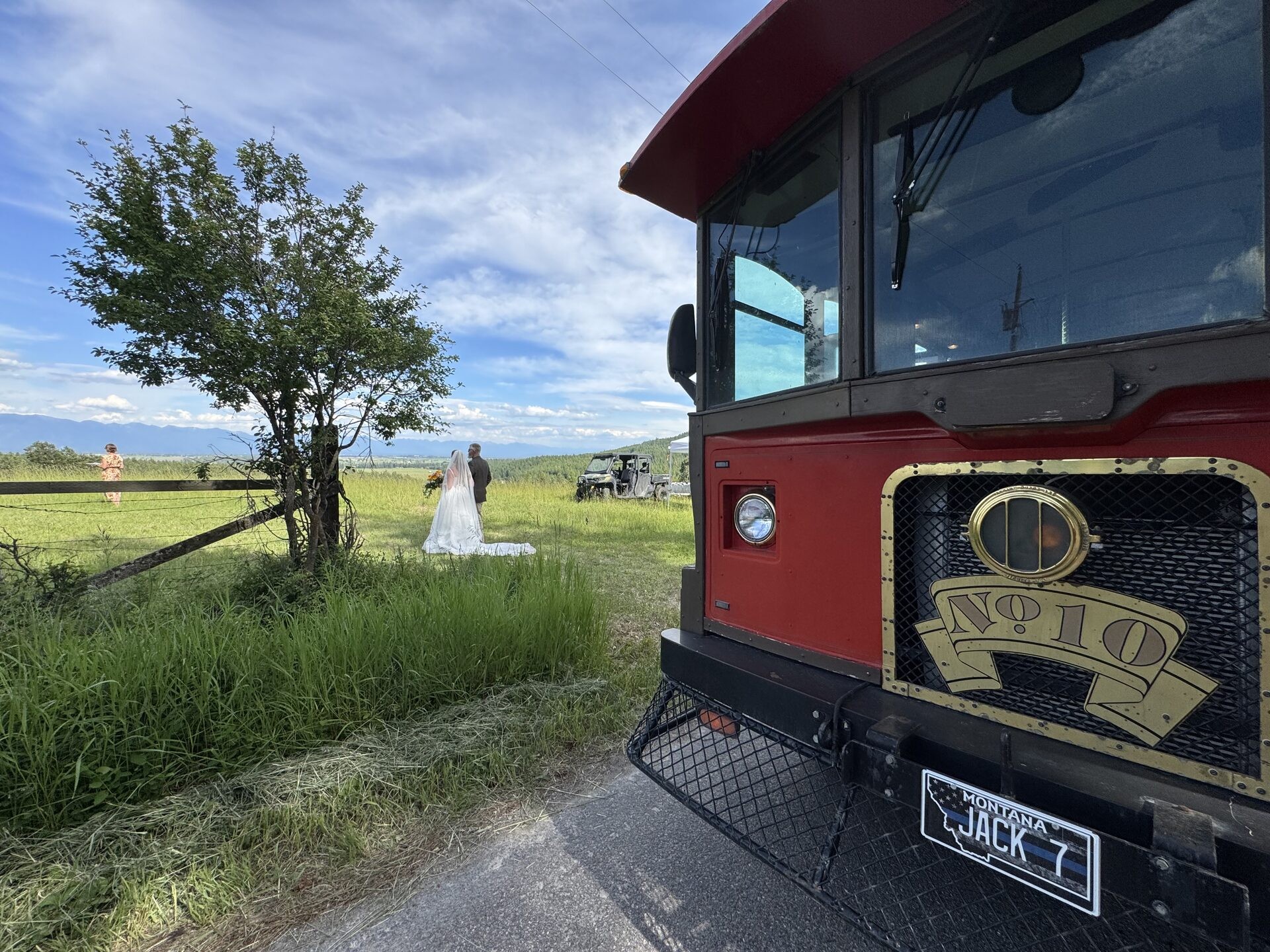Jack the trolley in the foreground with a wedding couple in a Montana field