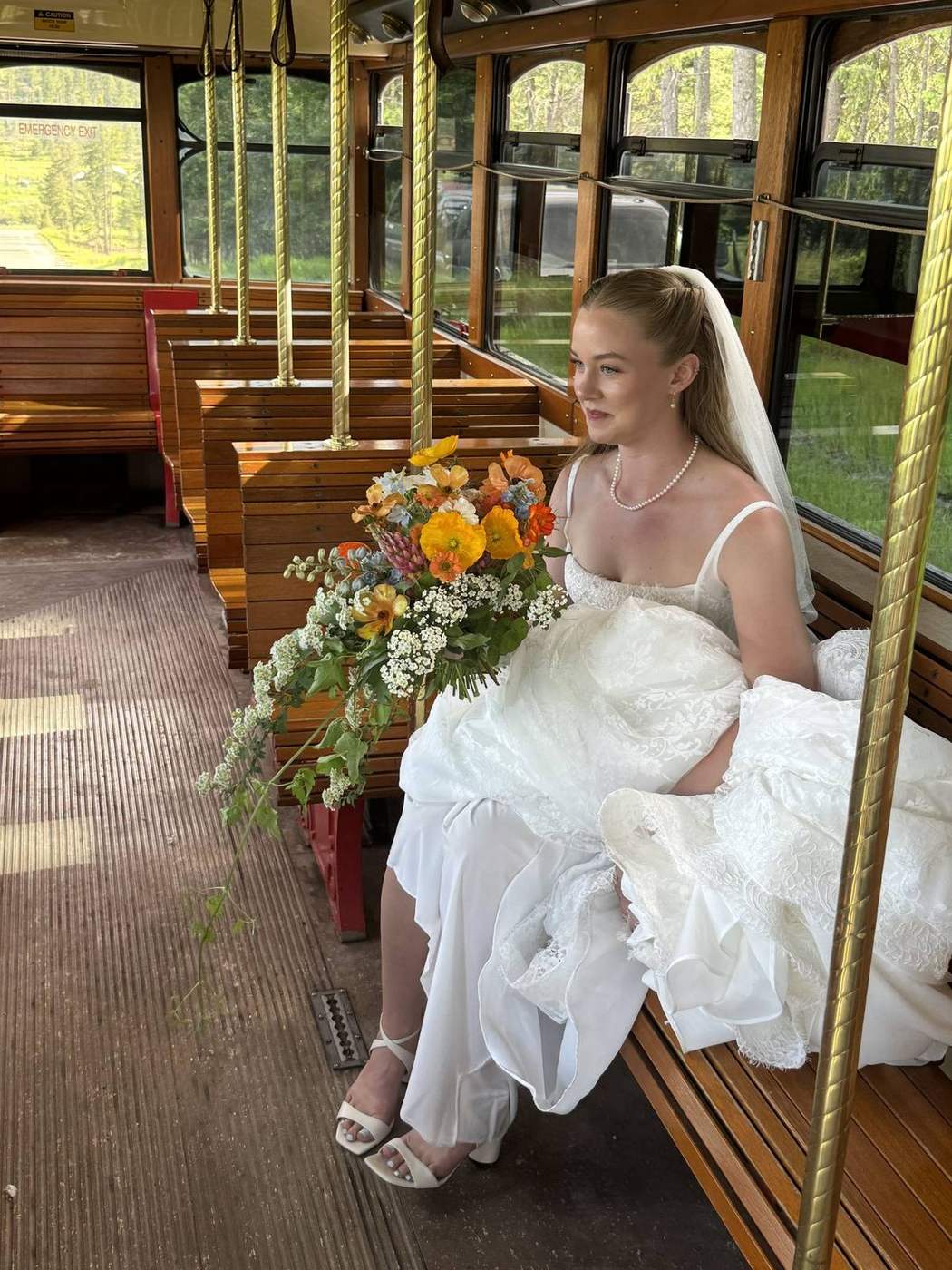 Bride seated inside a Montana trolley with bouquet