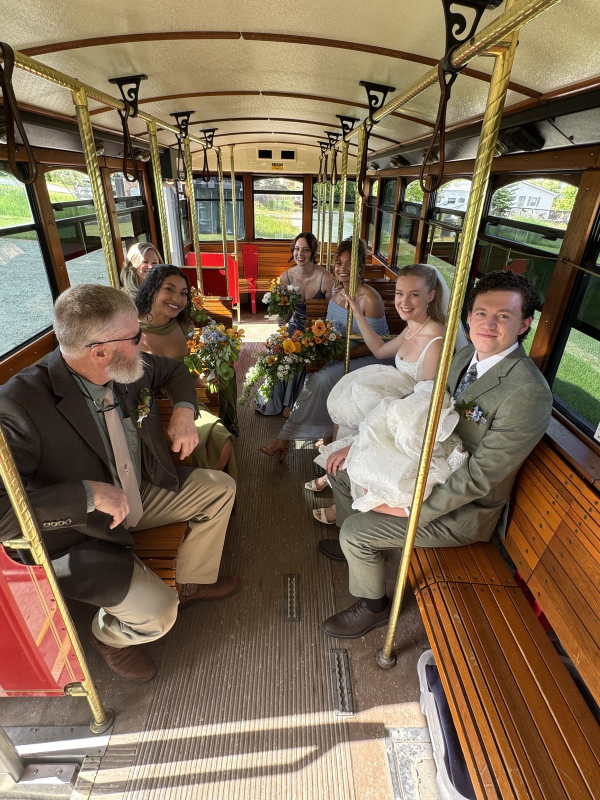 Wedding party seated inside a sunlit Montana trolley