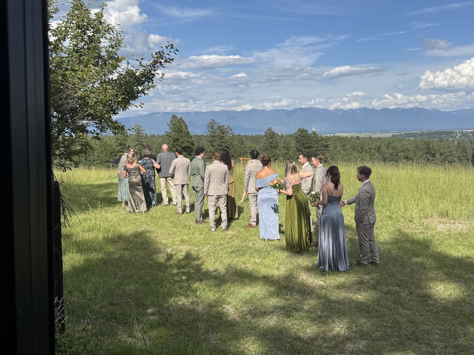 Bridal party walking through a green Montana field