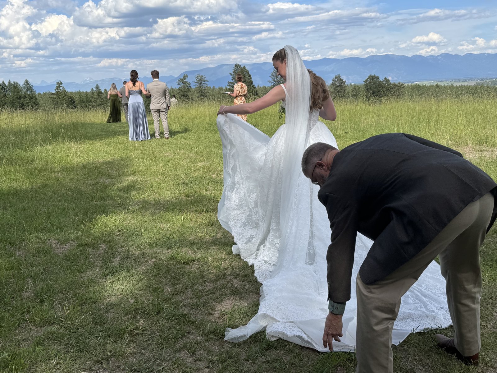 Wedding party arranging a bride veil in a Montana field