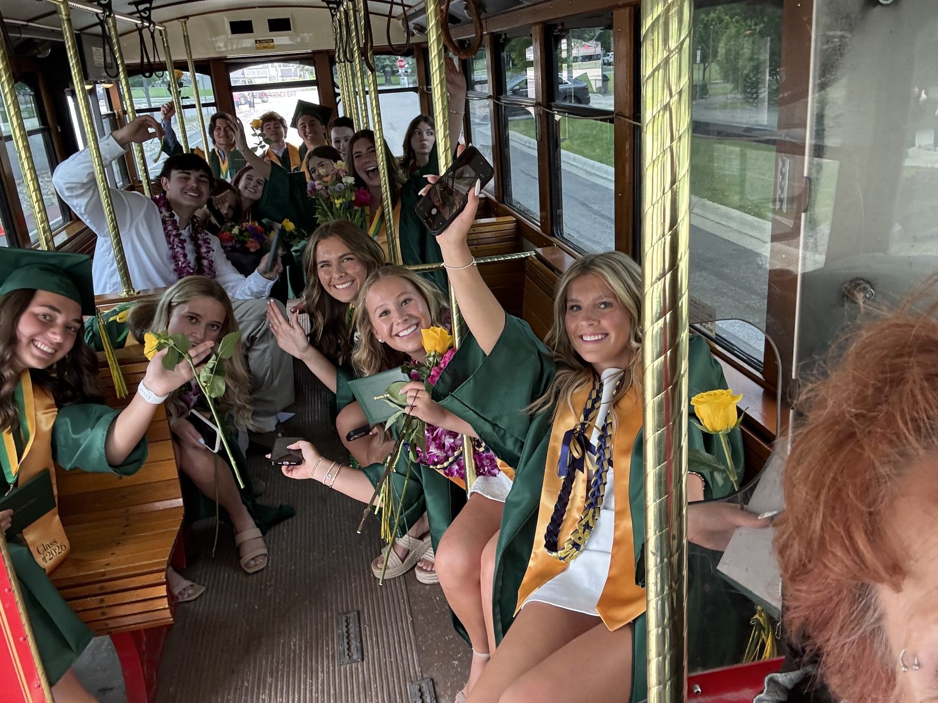 Graduates celebrating inside a Montana trolley