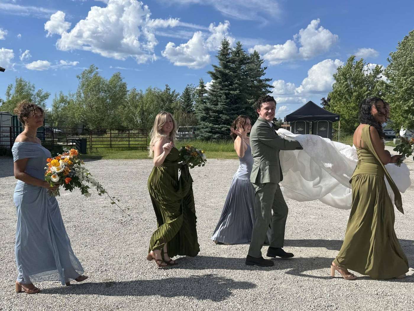 Wedding party celebrating beside a Montana trolley on a sunny day